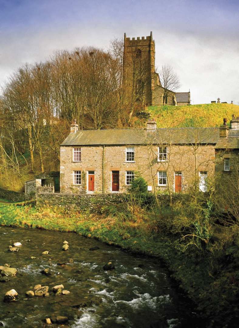 Water rushes between the pretty church at Ingleton, part of the Ingleton Waterfall Trail